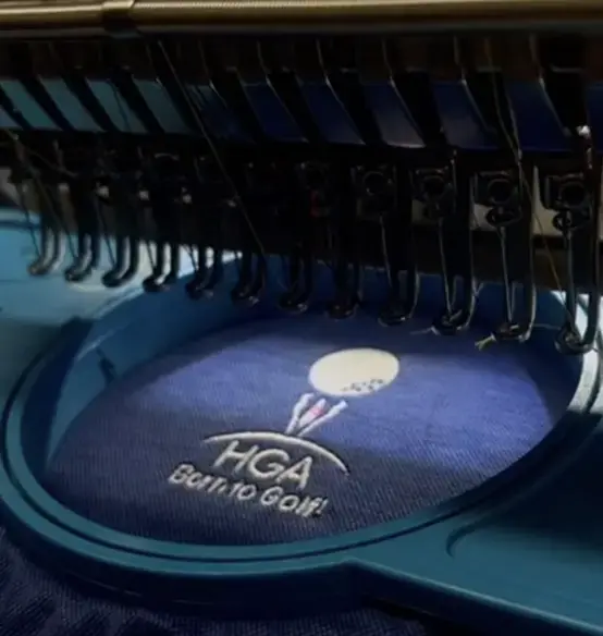 HGA golf logo being embroidered in a hoop