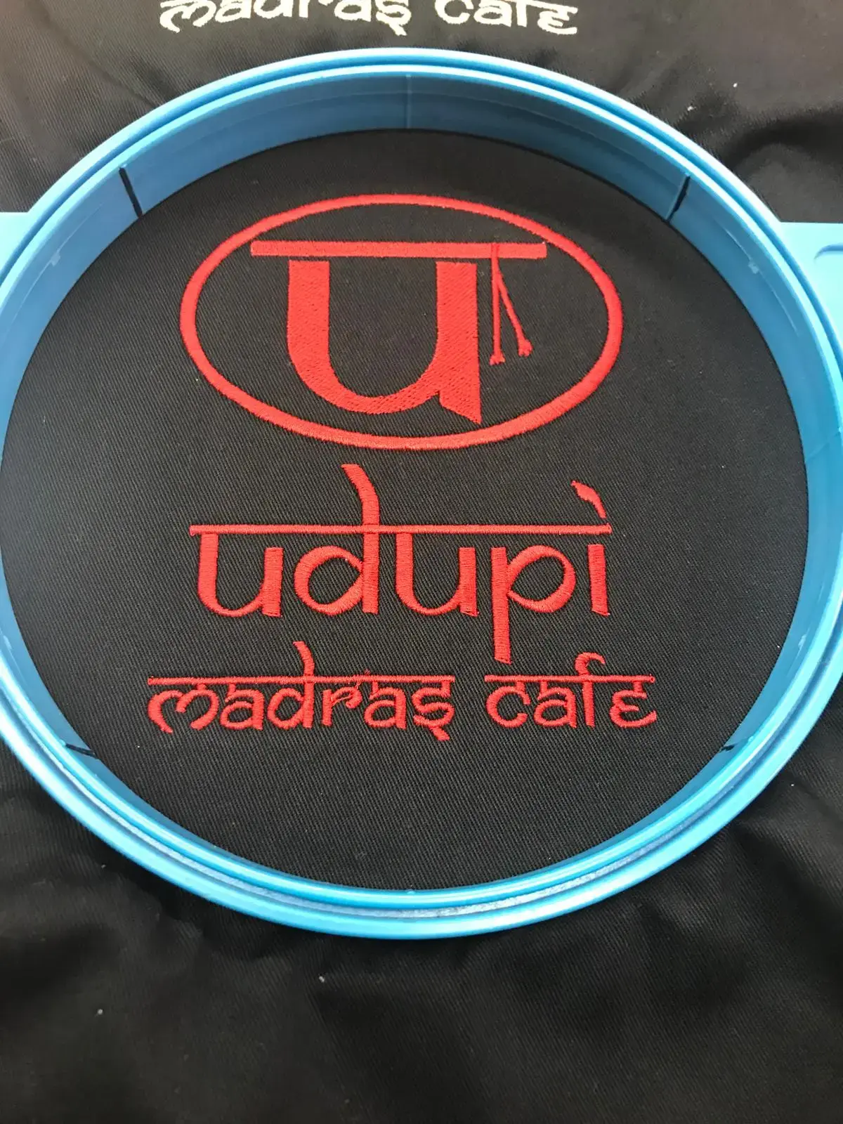 Restaurant logo embroidered in red and white thread