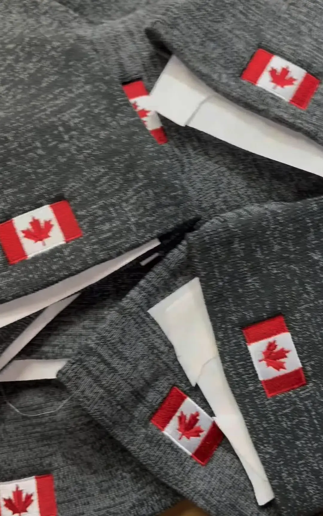 Grey beanies embroidered with Canadian flag patches