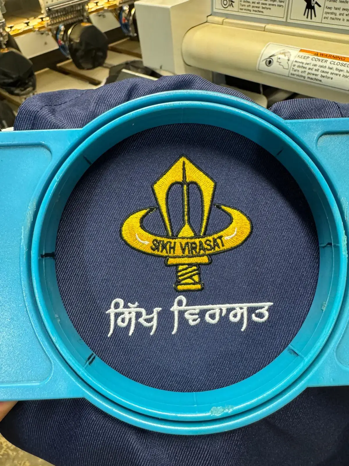 Gold religious emblem embroidered on navy fabric