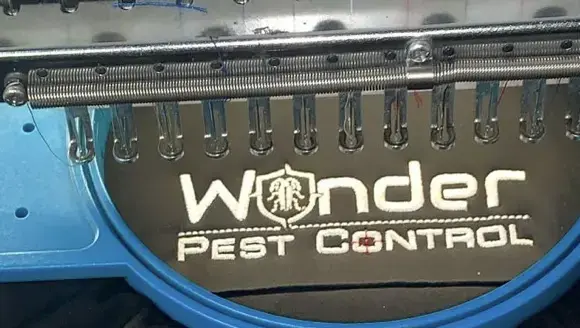Wonder Pest Control uniform logo in white thread