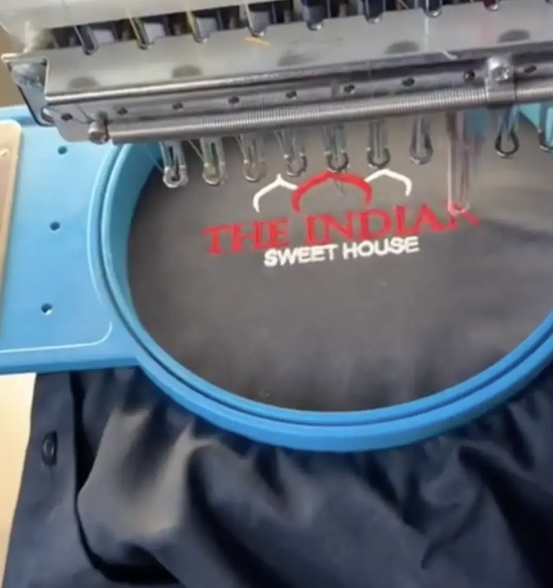 Red custom lettering embroidered on grey fabric