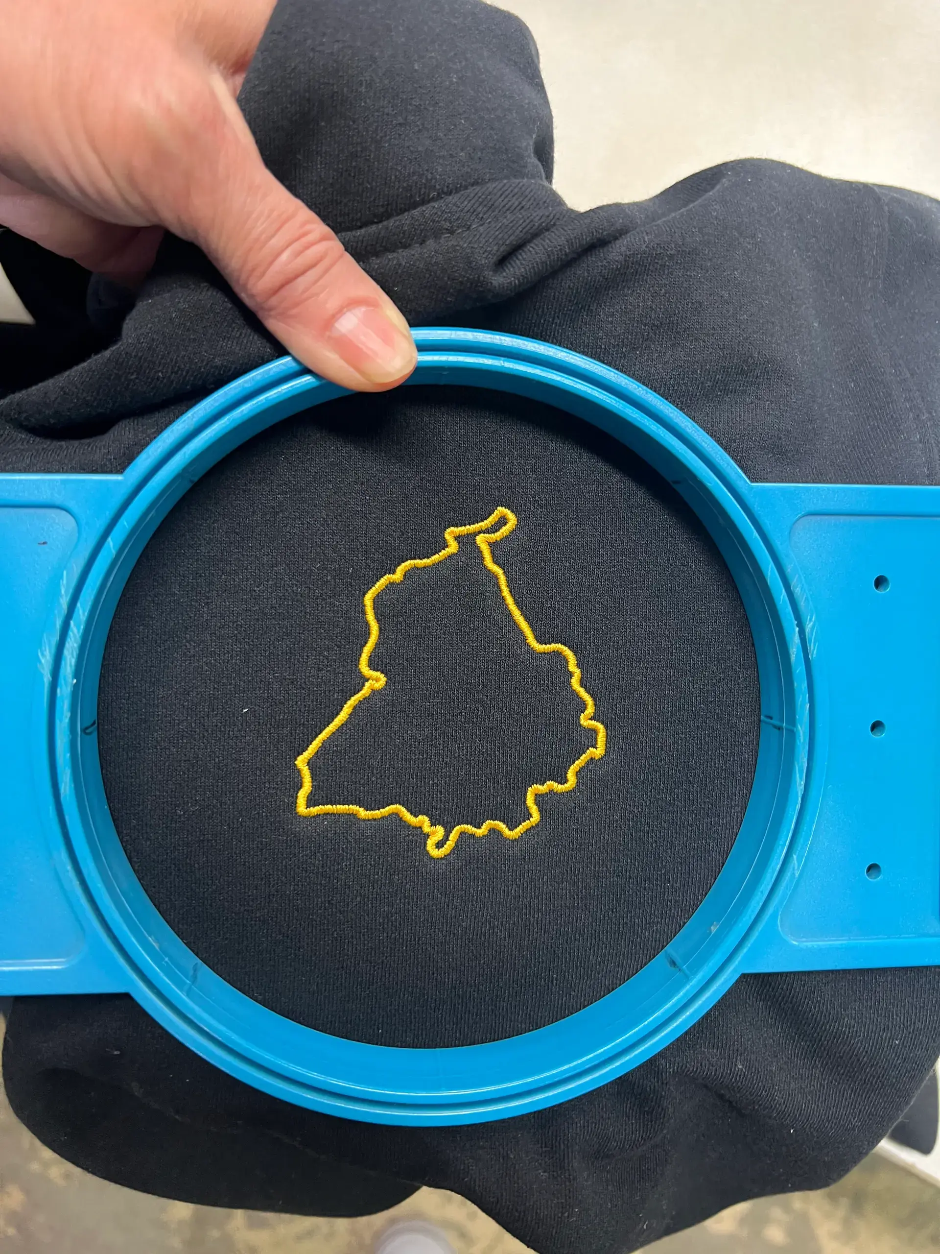 Gold outline emblem stitched onto black fabric