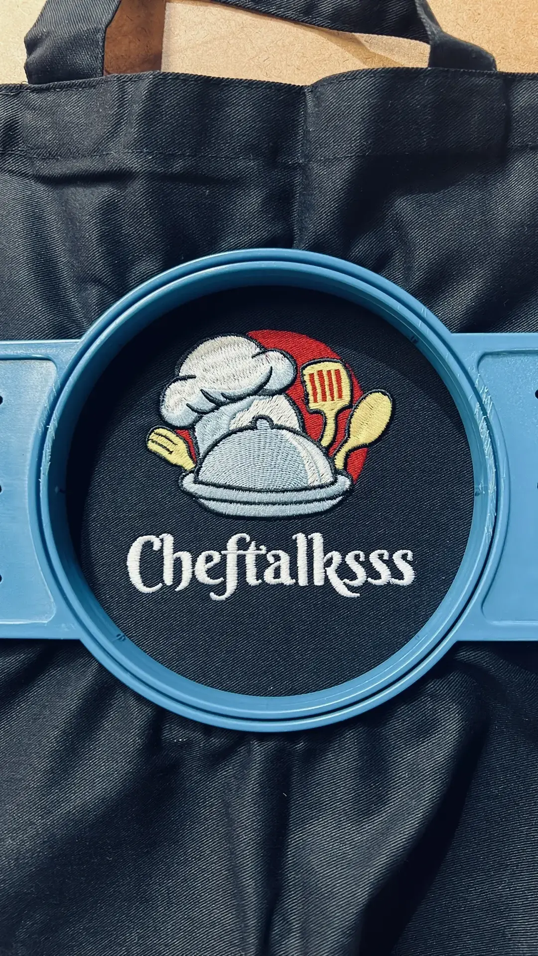 Chef-themed logo embroidered on bright blue fabric