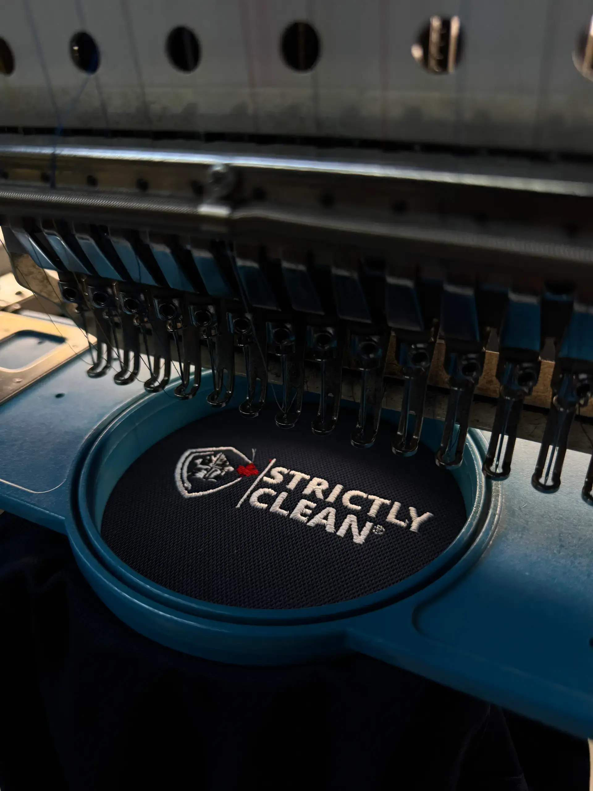 Black garment receiving a circular white logo