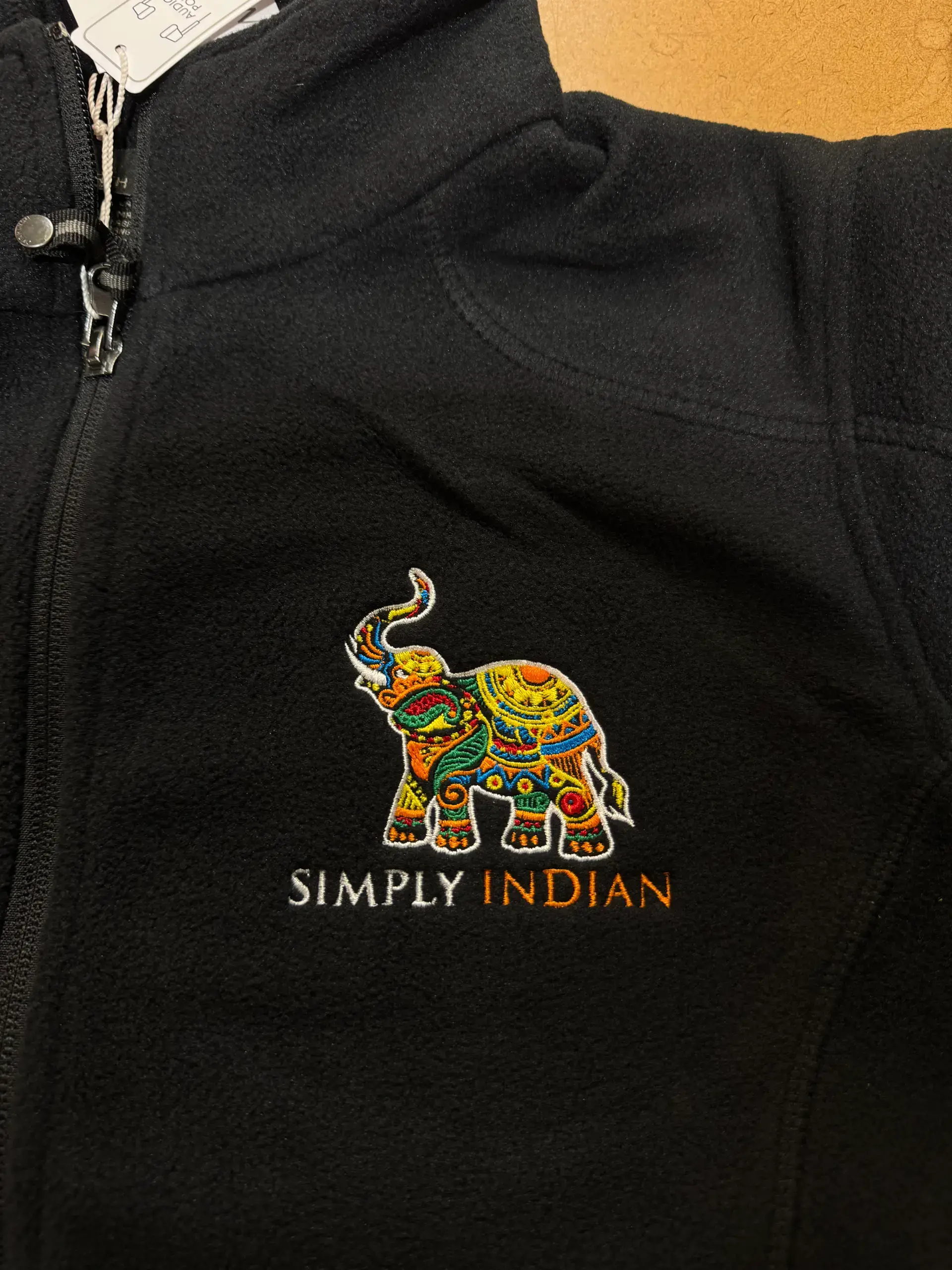 Small multicolour elephant embroidered on black fabric