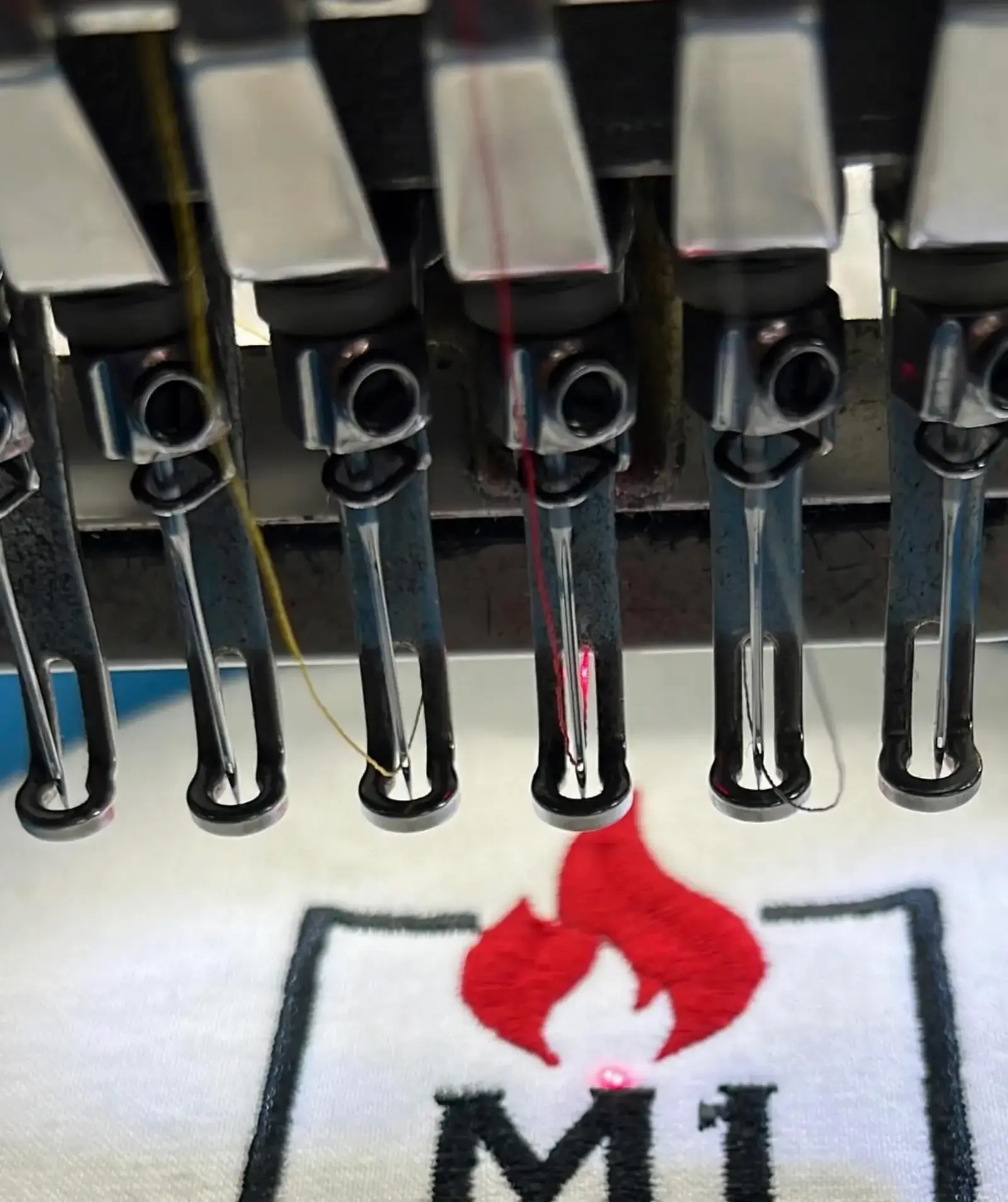Embroidery machines stitching a custom design at 6iX Embroidery
