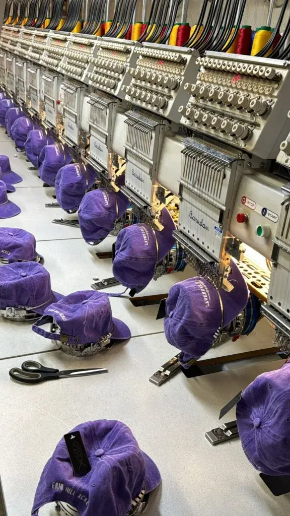 Purple caps arranged across a multi-head embroidery production line